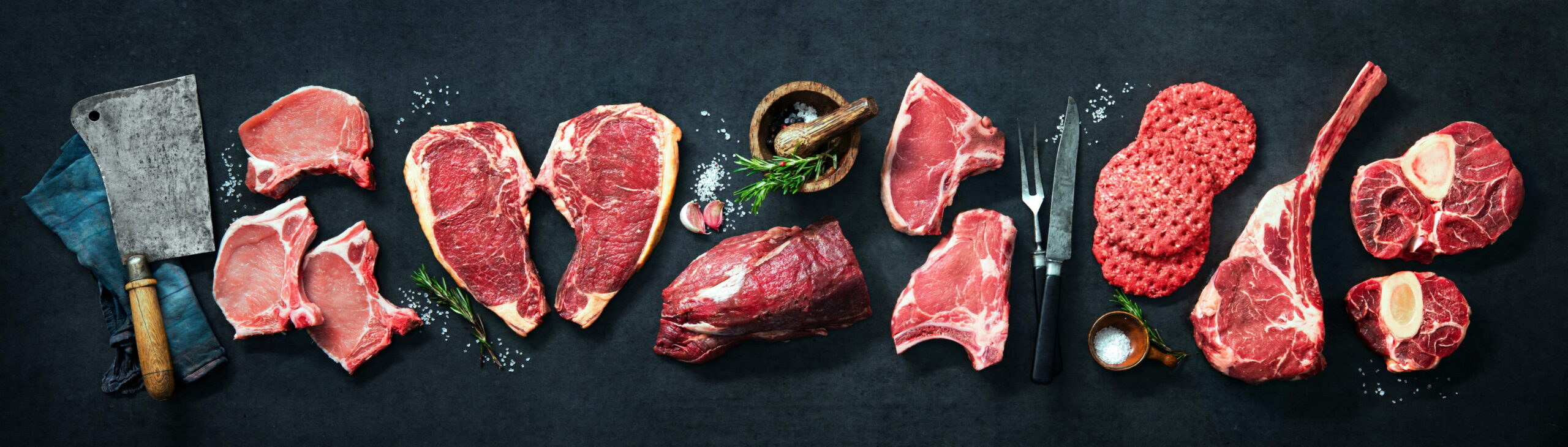 spread of 7 types of beef cuts on a black background with knife