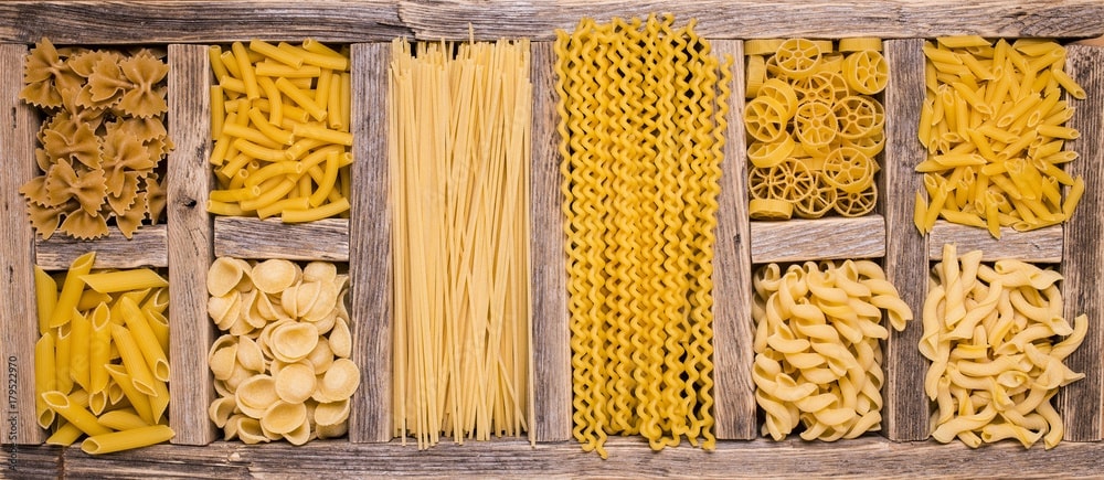 homemade pasta in wooden box with different compartments with different types of pasta